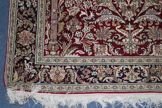 An Indian silk red ground rug
